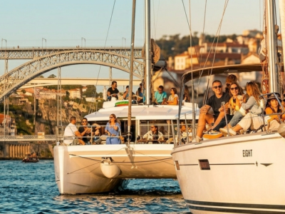 Grupo disfrutando de un paseo en velero por el río Duero frente al puente Luis I en Oporto