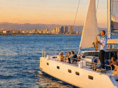 Vista de un atardecer dorado desde un barco navegando por la costa de Barcelona con TiToTravel.