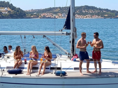 Velero privado en Lisboa con grupo de personas disfrutando de una barbacoa a bordo en el mar