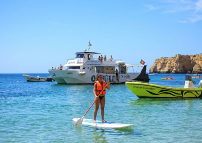 Persona haciendo paddle surf en el mar con catamarán en Algarve