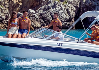 Barco privado navegando por la costa de Arrábida en Setúbal con personas disfrutando del paseo en el mar