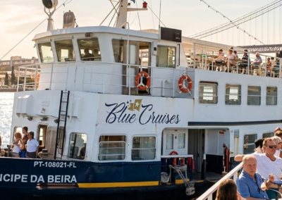 Barco turístico navegando por el río Tajo en Lisboa con personas disfrutando del brunch a bordo.