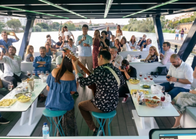 Pasajeros disfrutando de música en directo a bordo de un barco privado en el río Guadalquivir en Sevilla