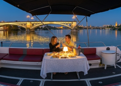 Pareja disfrutando de una cena romántica en un barco privado por el río Guadalquivir en Sevilla.