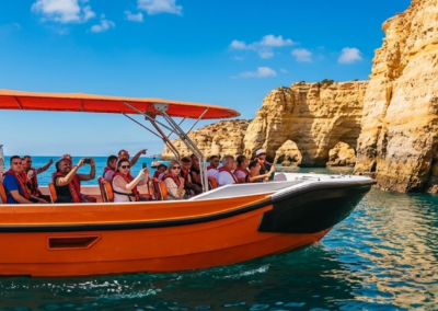 Barco turístico con pasajeros visitando la Cueva de Benagil y los acantilados del Algarve desde Vilamoura.