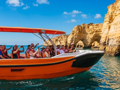 Barco turístico con pasajeros visitando la Cueva de Benagil y los acantilados del Algarve desde Vilamoura.