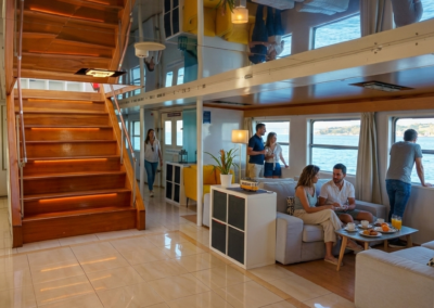 Turistas relajándose en la zona lounge interior de un barco durante un crucero por el río Tajo en Lisboa.