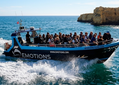 barco rápido con pasajeros navegando por la costa del Algarve cerca de Benagil
